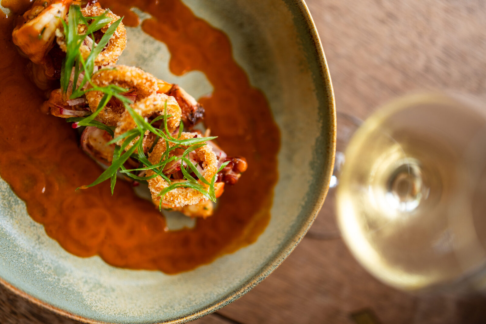 A plated seafood main course in a rich sauce, photographed from above at Cheetah Plains