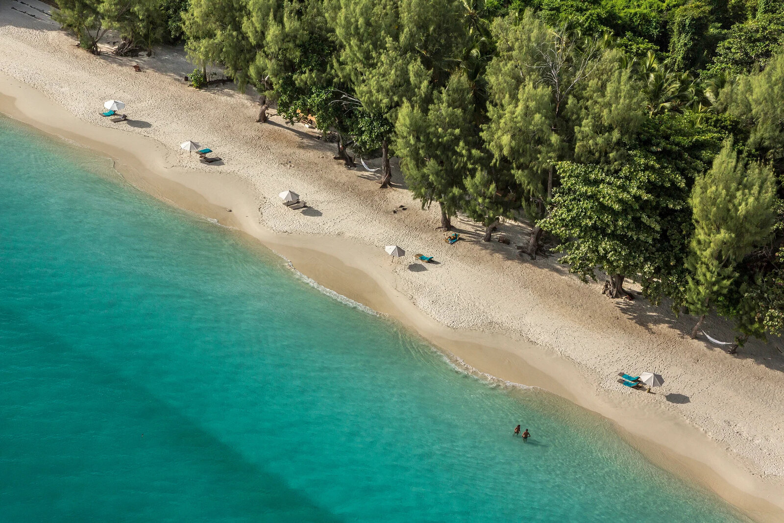 Sun loungers in the shade of palms on the beach at Constance Tsarabanjina, Madagascar