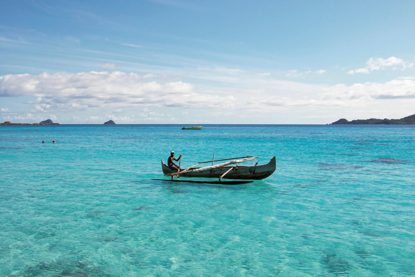 A traditional wooden pirogue on turquoise water in the Mitsio Archipelago near Constance Tsarabanjina, Madagascar
