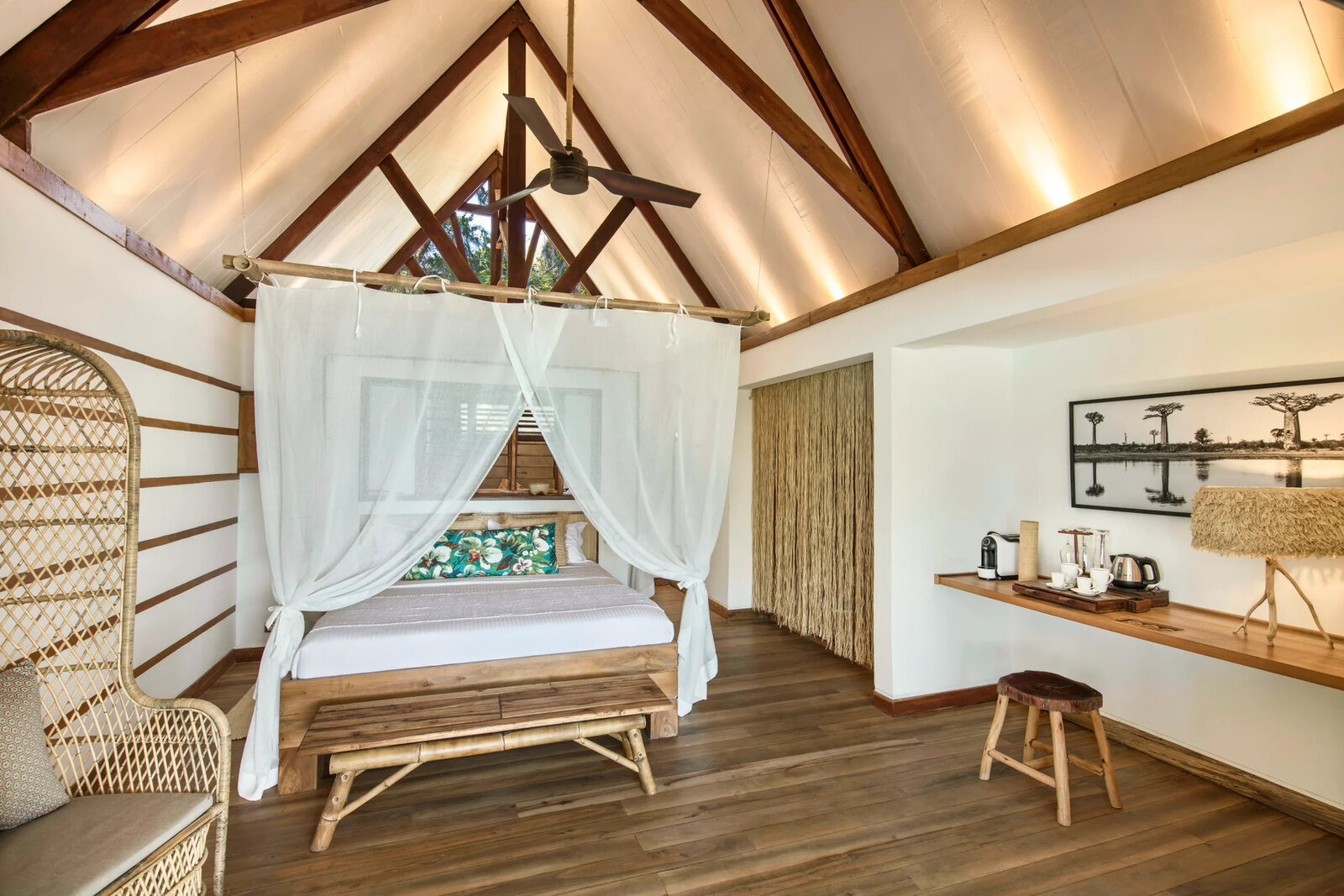 Inside a beach villa with a canopied bed and rosewood detailing at Constance Tsarabanjina, Madagascar