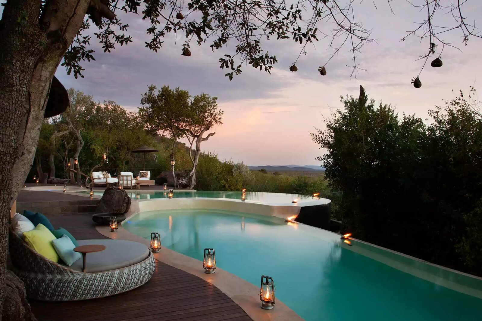 An infinity pool and deck at a private lodge at dusk