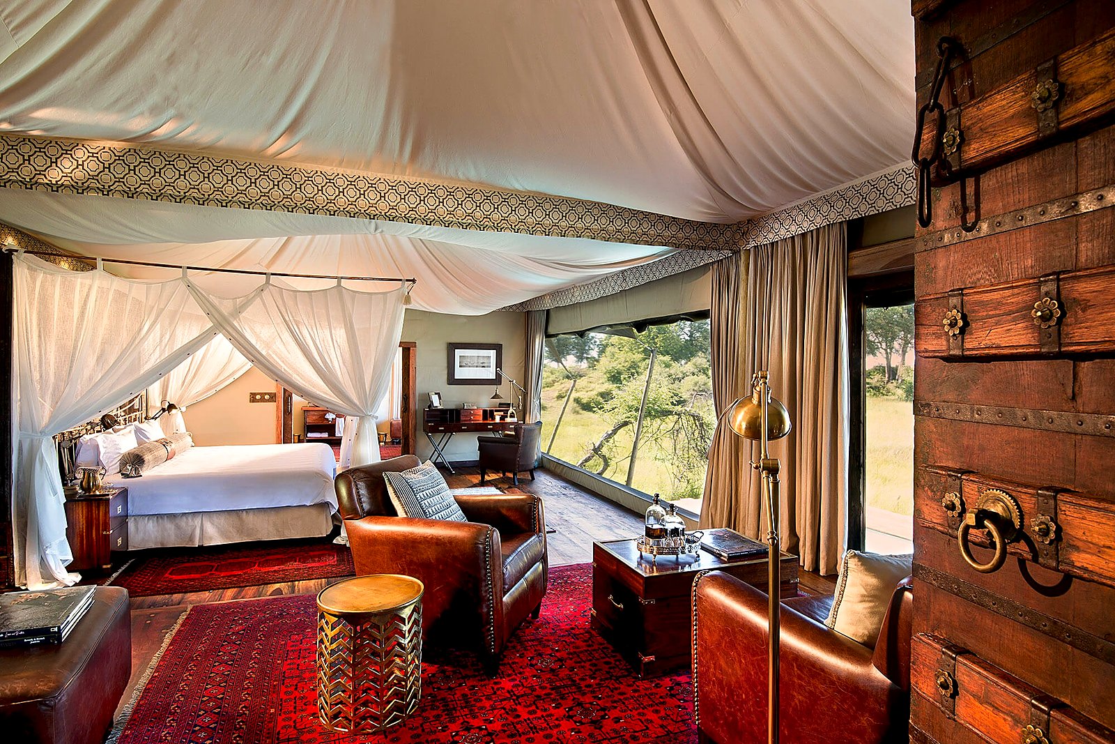 Tented suite bedroom in canvas and brass at Duba Plains Camp