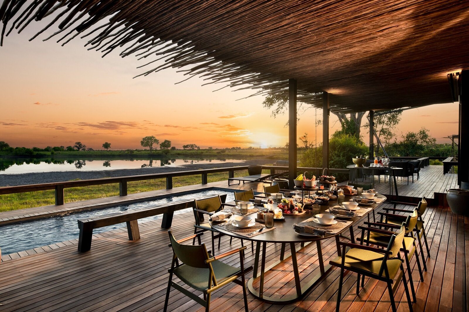 Outdoor dining deck at Dulini with sunset views over the Sand River