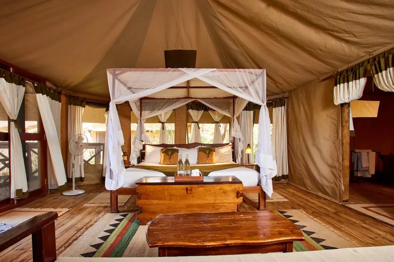 Tent interior with four-poster bed draped in mosquito netting