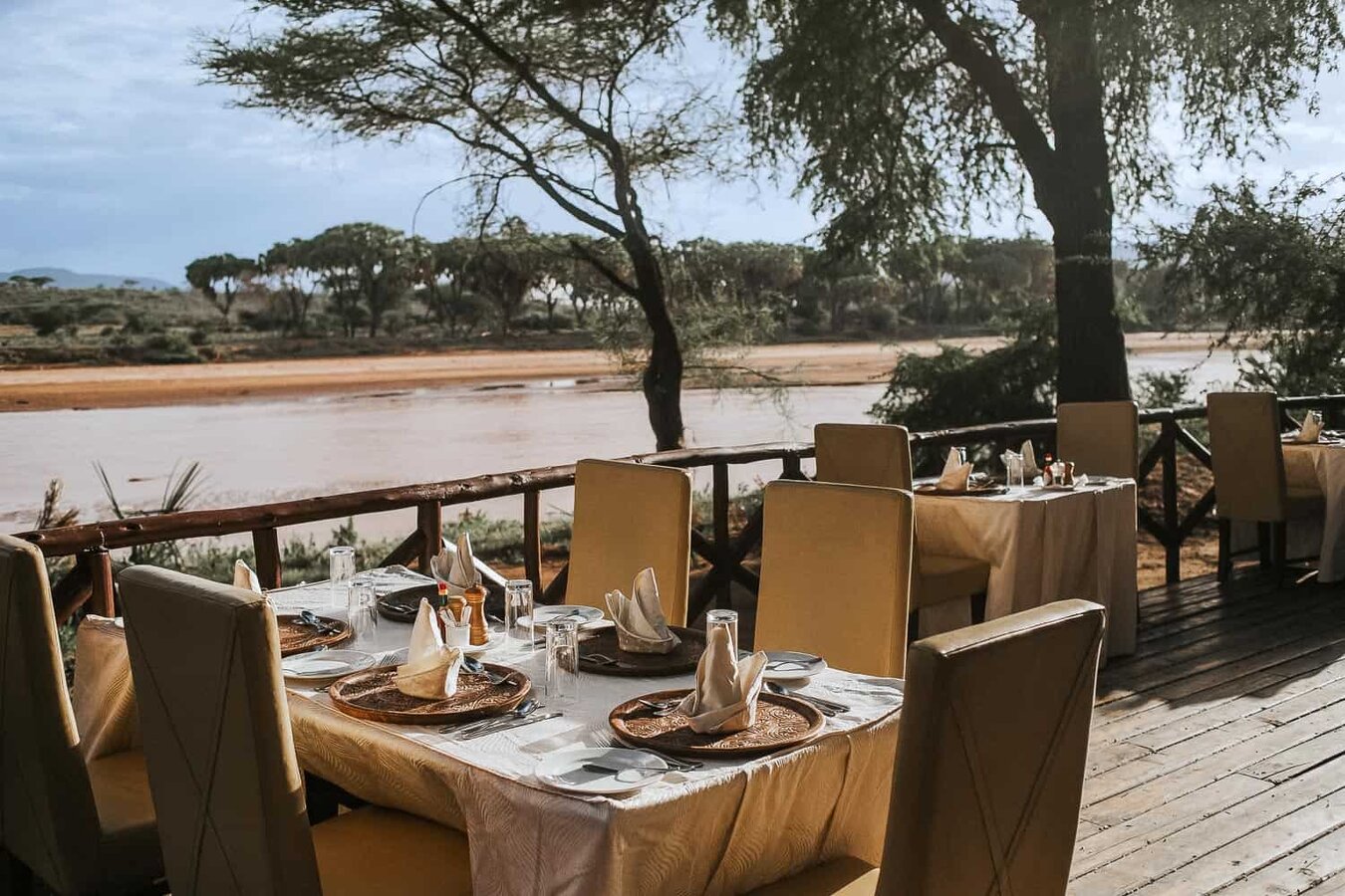 Dining tables set on the deck with sweeping river views