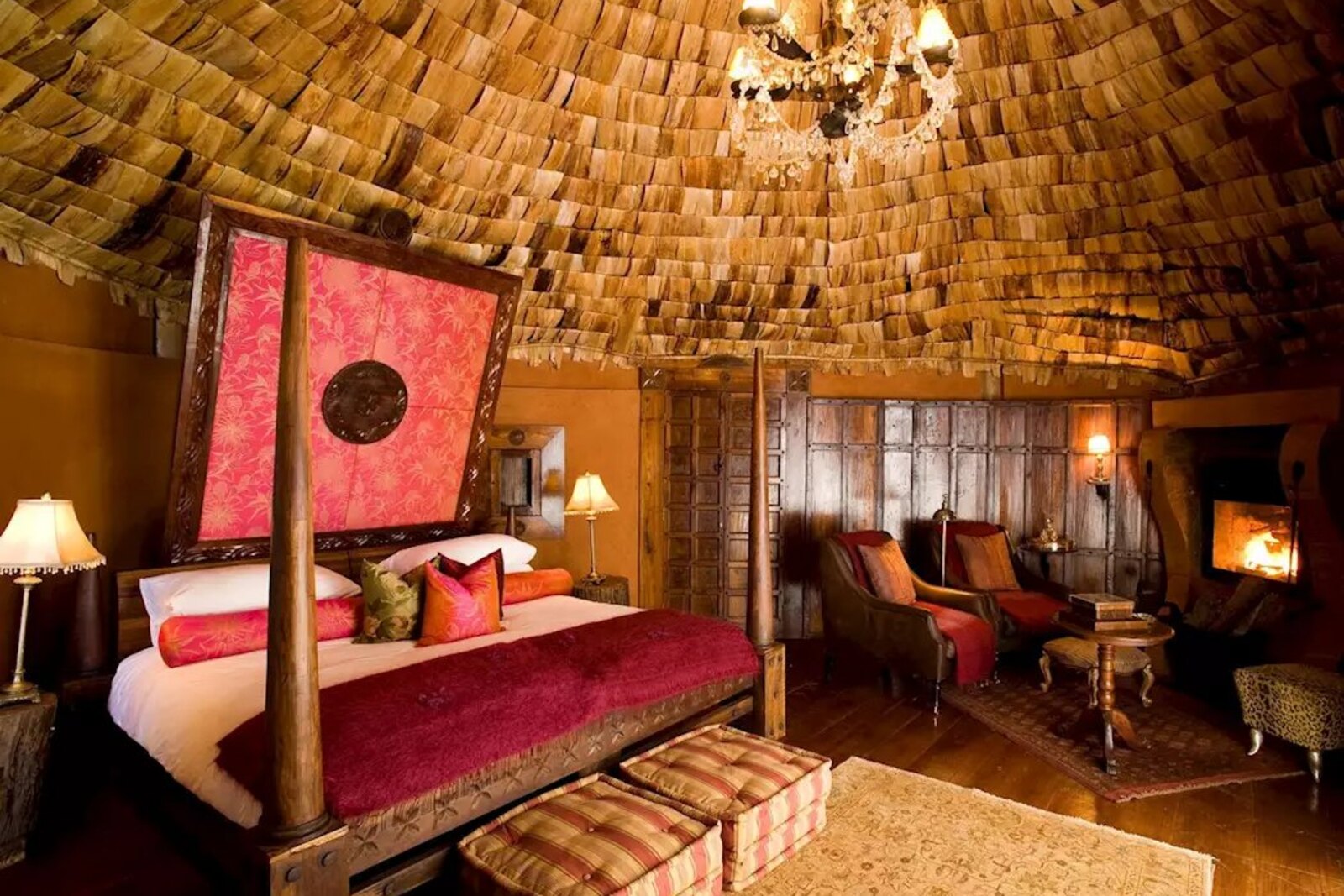 Ngorongoro Crater Lodge suite with fireplace, four-poster bed and rich fabrics
