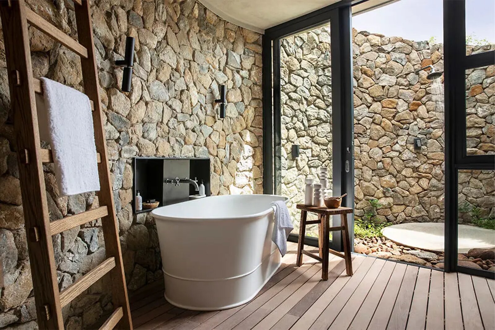 Stone en-suite bathroom with indoor shower in an Indlu suite at Fifty-Five Mjejane