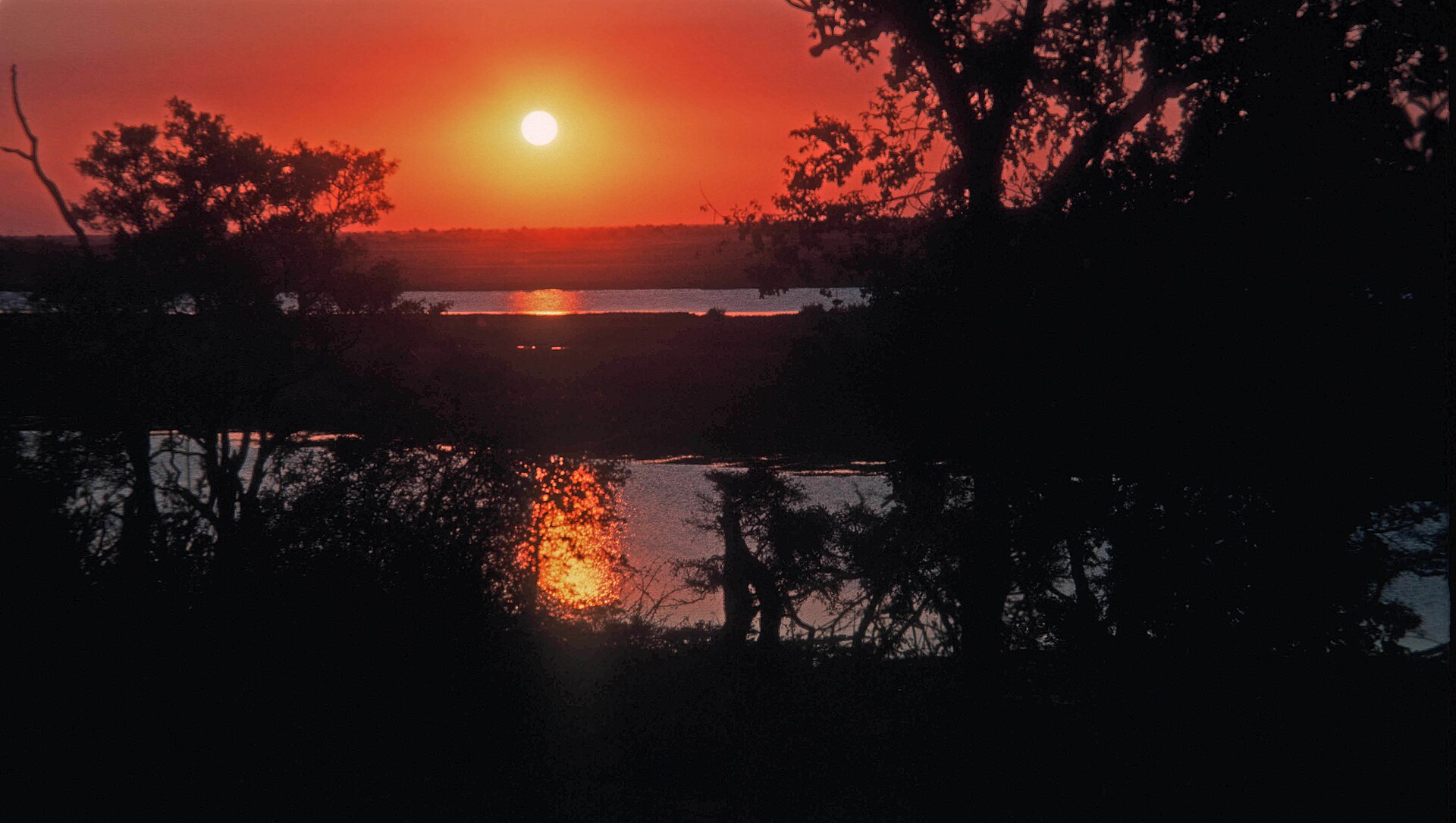 Golden sunset over the river with safari boat silhouette