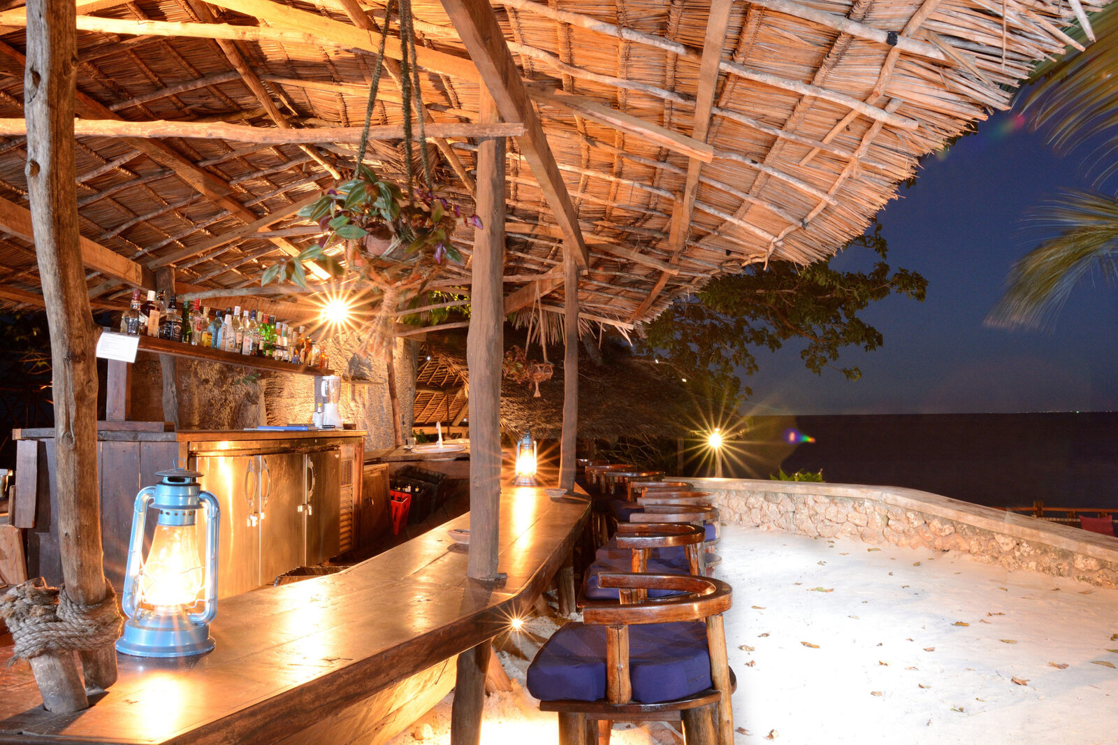 The Dhow FumBar lit by lanterns at dusk at Fumba Beach Lodge, Zanzibar