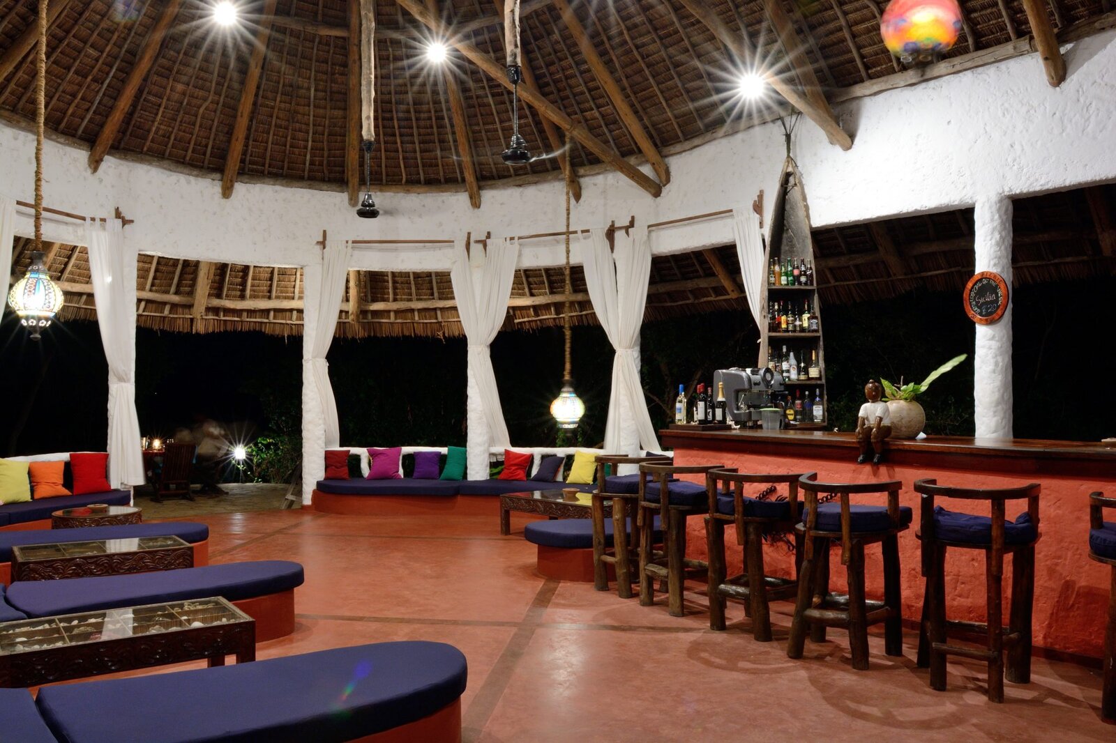 Open-sided thatched lounge with colourful sofas at Fumba Beach Lodge