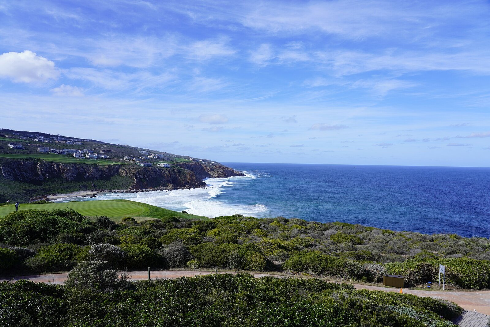 A scenic coastal road winding along cliffs at golden hour on the Garden Route