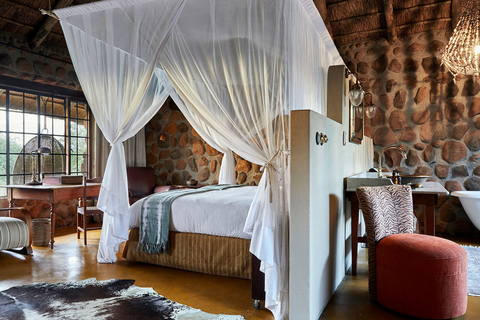 Outdoor rain shower with brass fittings against a stone wall at Geiger's Camp, Timbavati