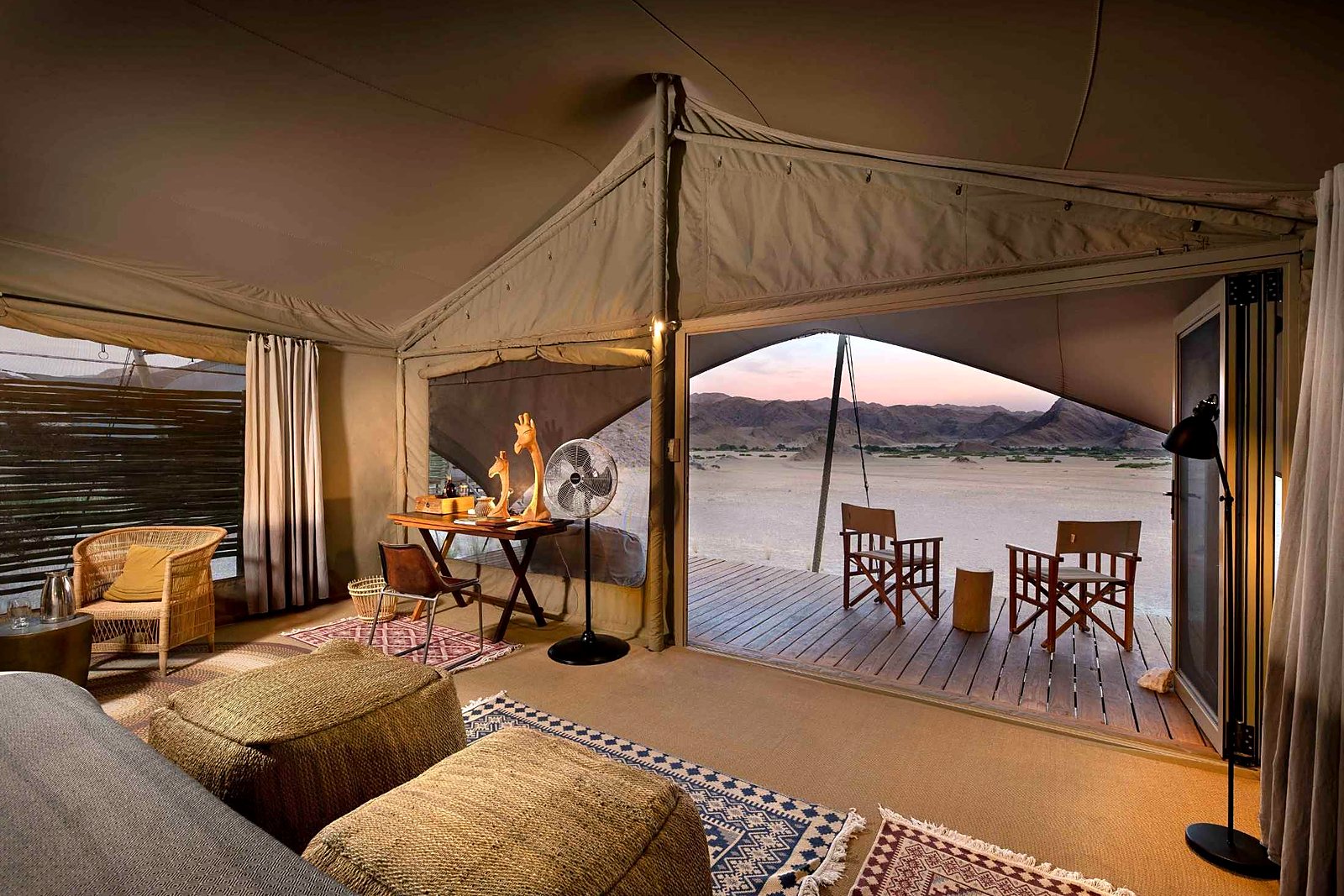 Elegant tented suite interior with bed and desert views at Hoanib Valley Camp