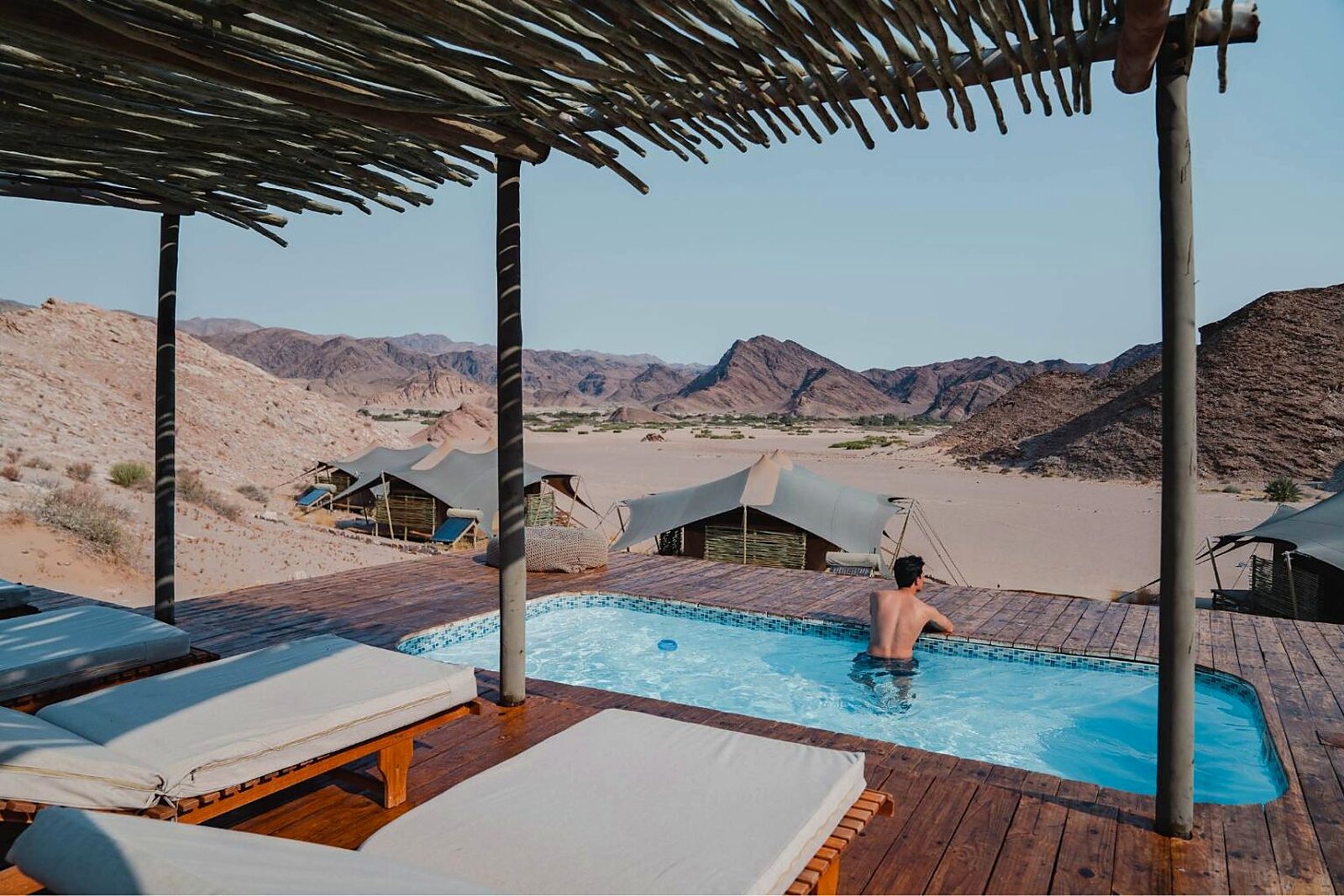 Shaded pool deck and desert surrounds at Hoanib Valley Camp, Kaokoveld