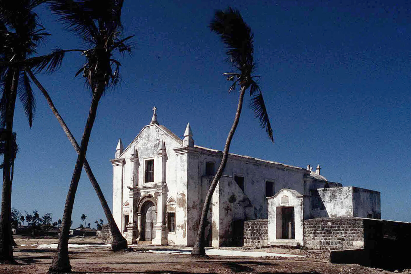 The white Chapel of Nossa Senhora de Baluarte framed by palms on Ilha de Moçambique