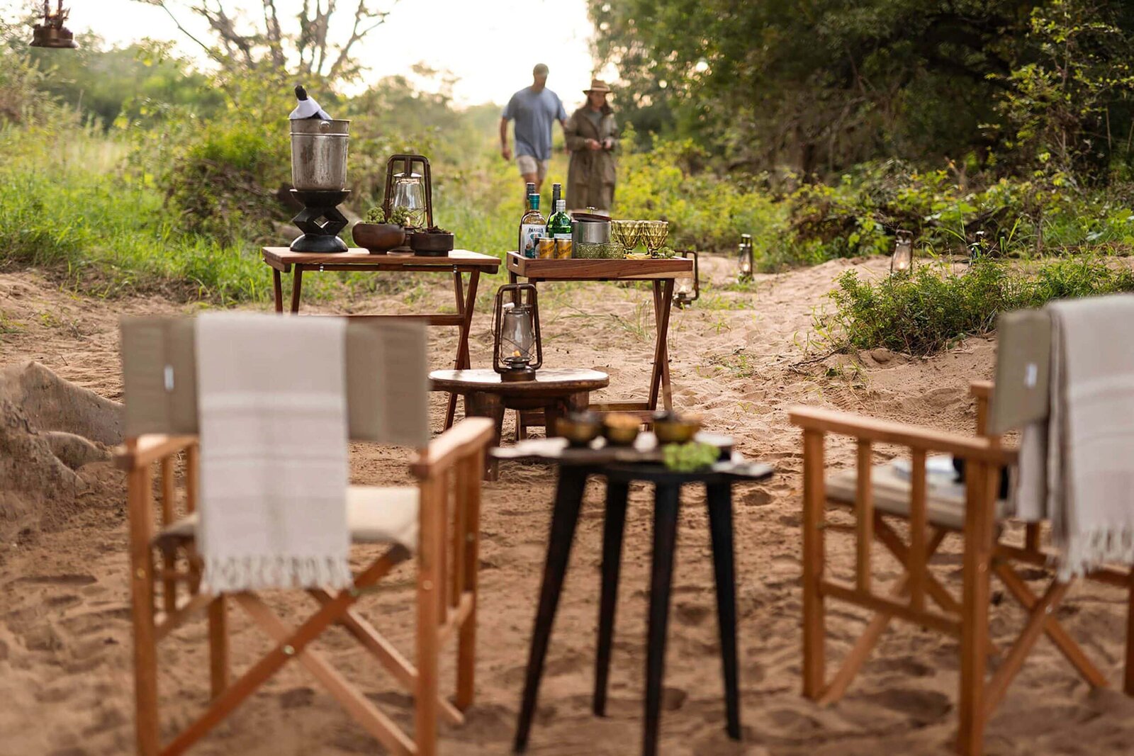 A riverbed sundowner set-up at Sepela Explorer Camp at Karongwe Private Game Reserve, director's chairs and hurricane lanterns in the sand at dusk