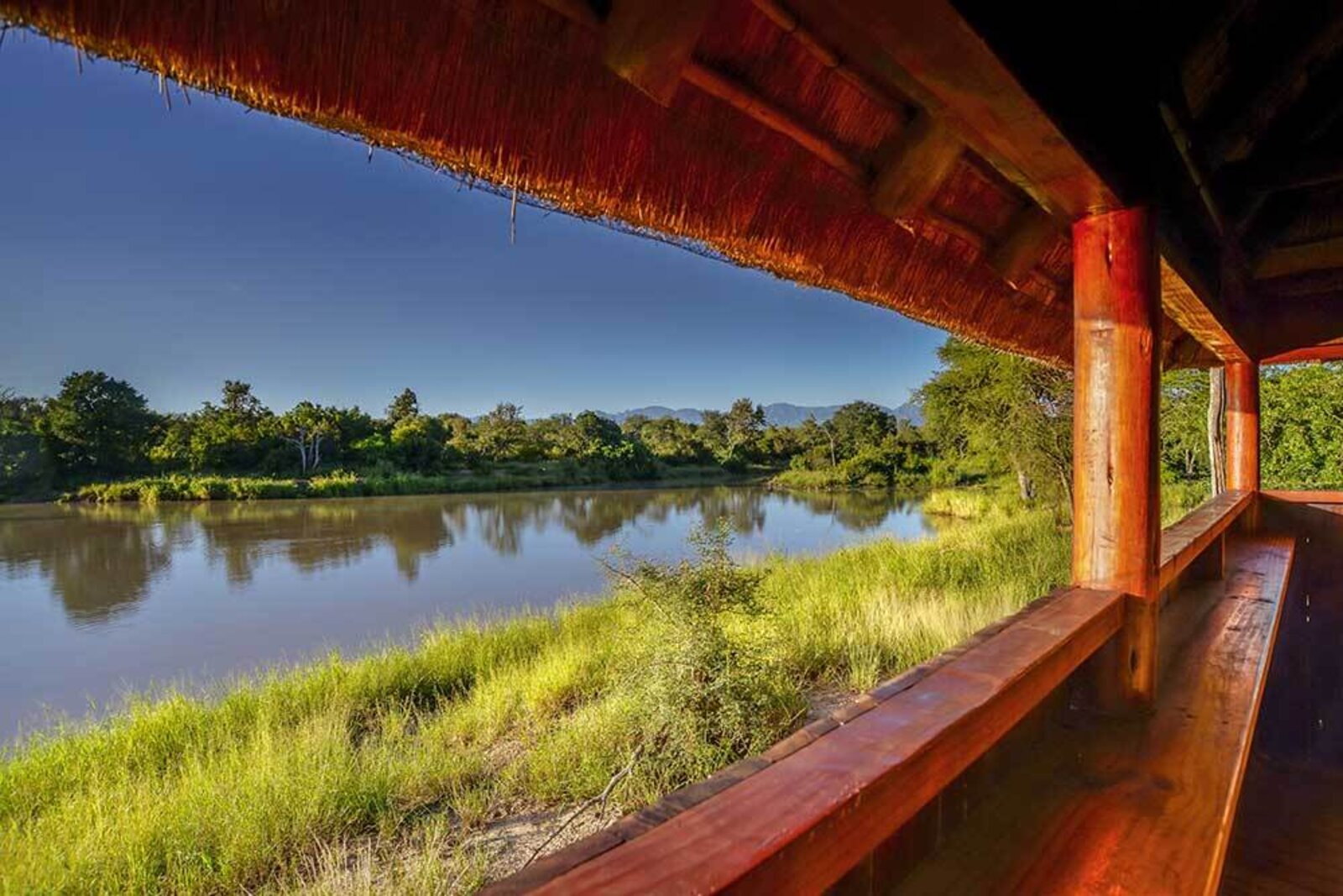 The thatched bird hide at River Lodge looking out over the reed-lined river at Karongwe Private Game Reserve