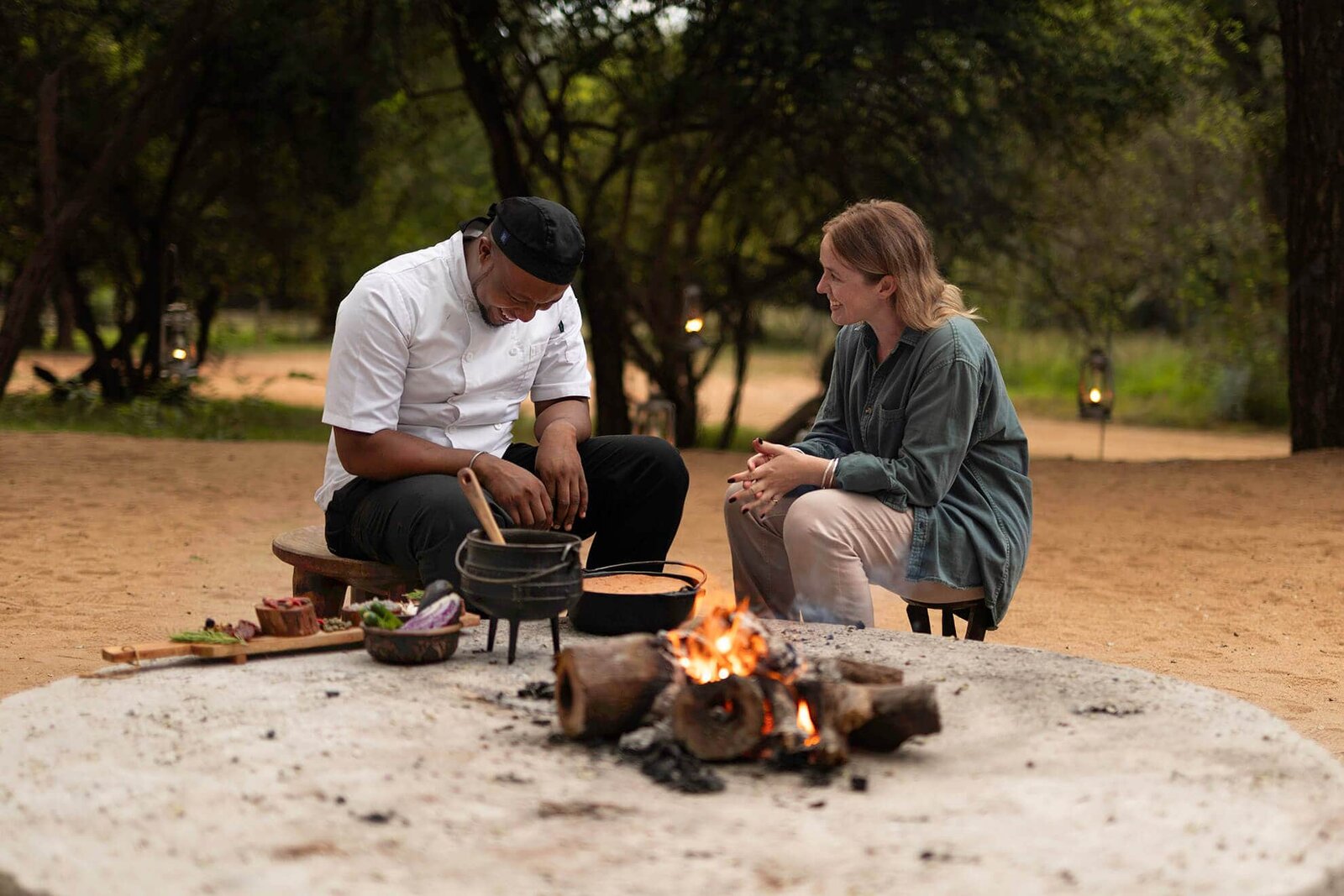 A boma bush dinner set with lanterns, a central fire and a starry sky at Karongwe Private Game Reserve