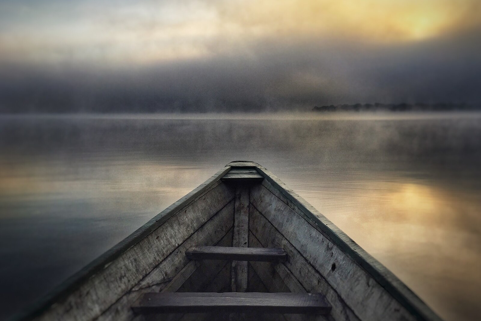 Wooden pirogue on misty Lake Rwihinda at dawn