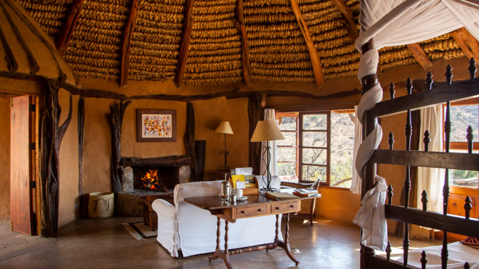 Cottage interior at Lewa Wilderness with stone walls and open fireplace