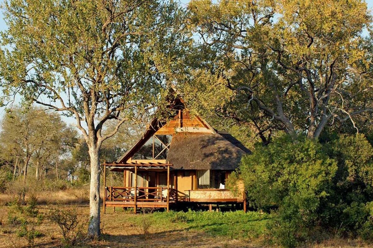 A Classic Suite bedroom at Lukimbi Safari Lodge with Swazi-inspired textiles and warm timber