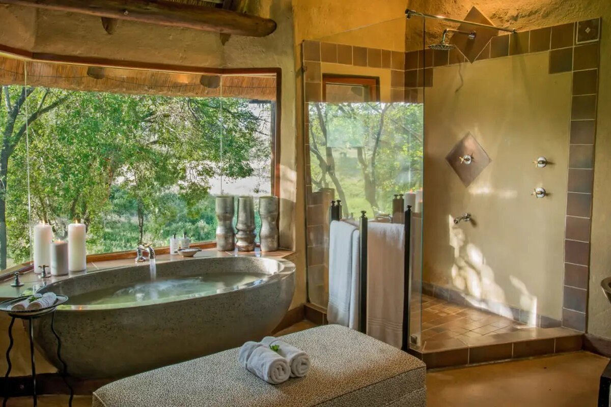 Luxurious premier suite bathroom at Lukimbi Safari Lodge with stone finishes