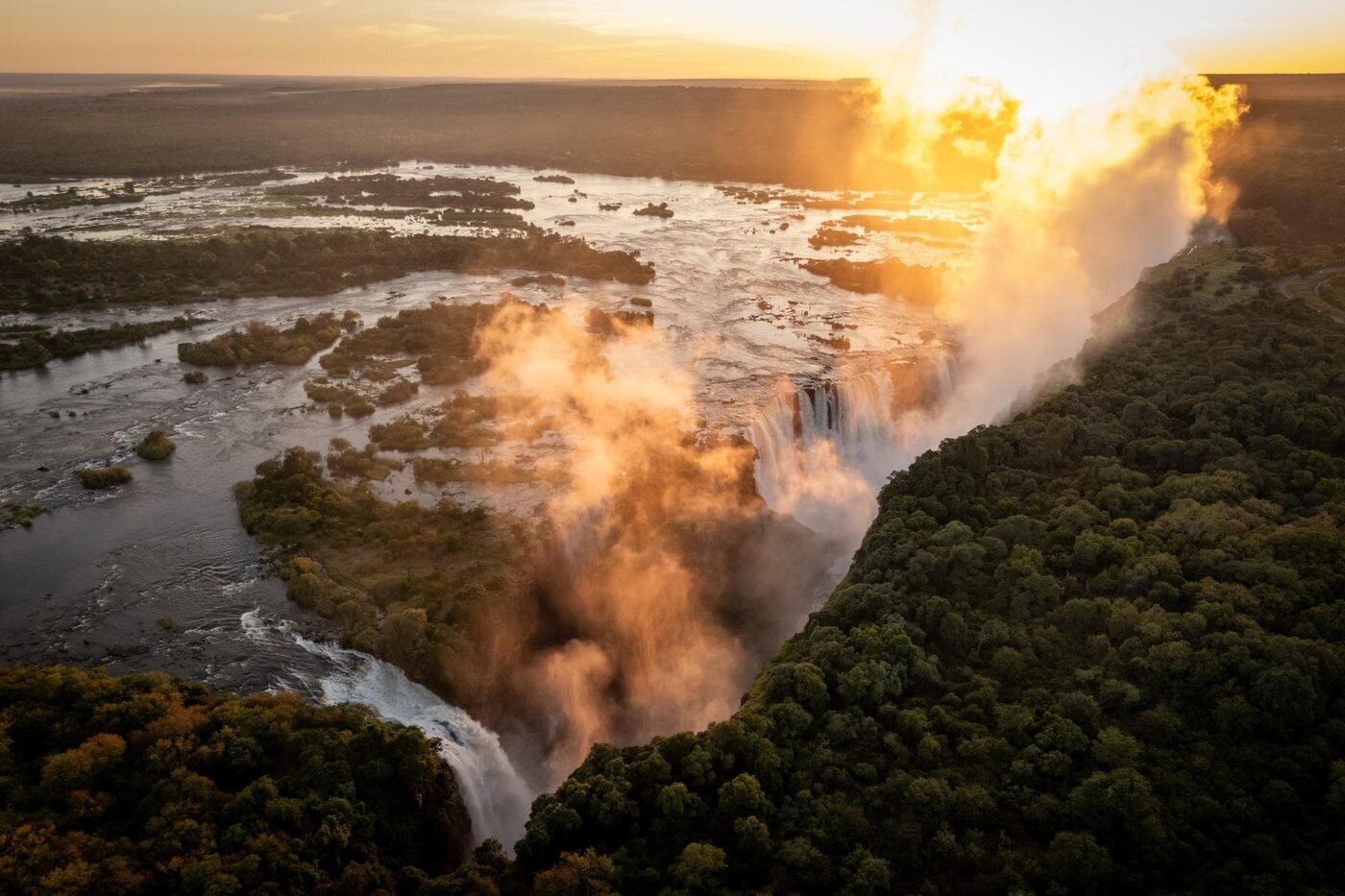 Victoria Falls glowing at sunset with rising spray