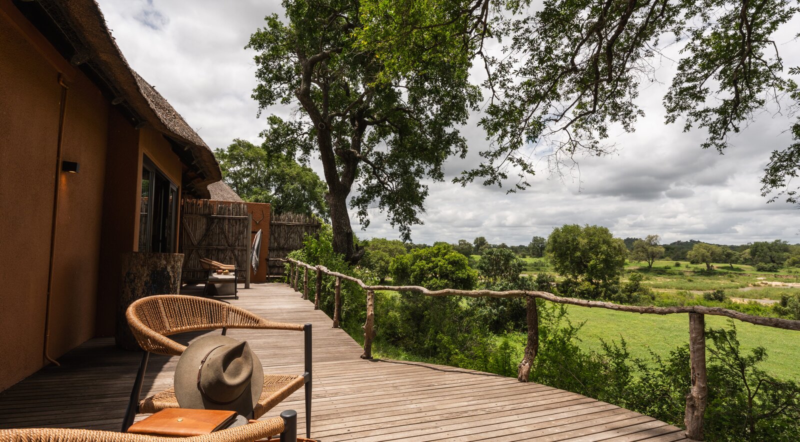 A private suite deck with chairs overlooking the open bush and Sand River at MalaMala