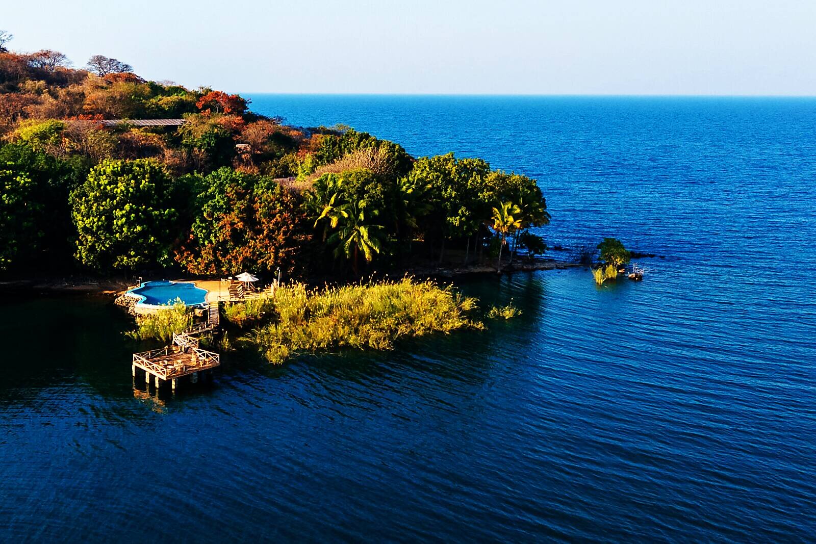 A private forested island rising from the blue waters of Lake Malawi