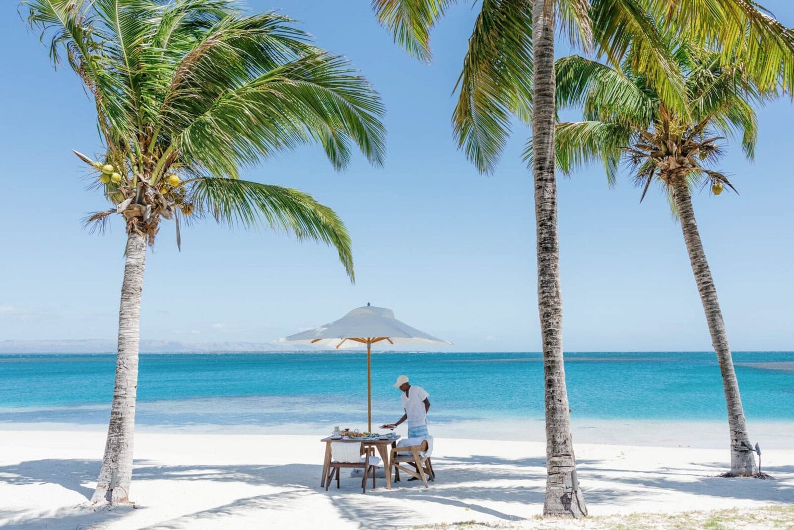 Breakfast set on the beach beneath palms at Miavana, Nosy Ankao, northern Madagascar