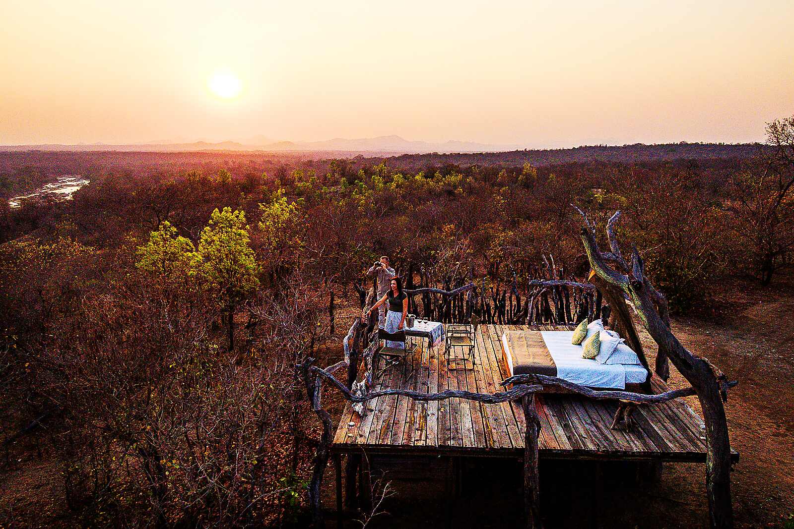 A sundowner dinner set on a deck overlooking the bush at sunset