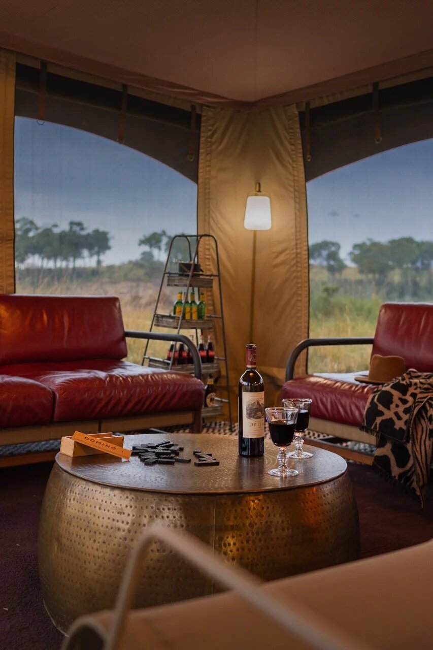A glass-fronted suite lounge with panoramic Masai Mara views at Angama Mara on a couples safari