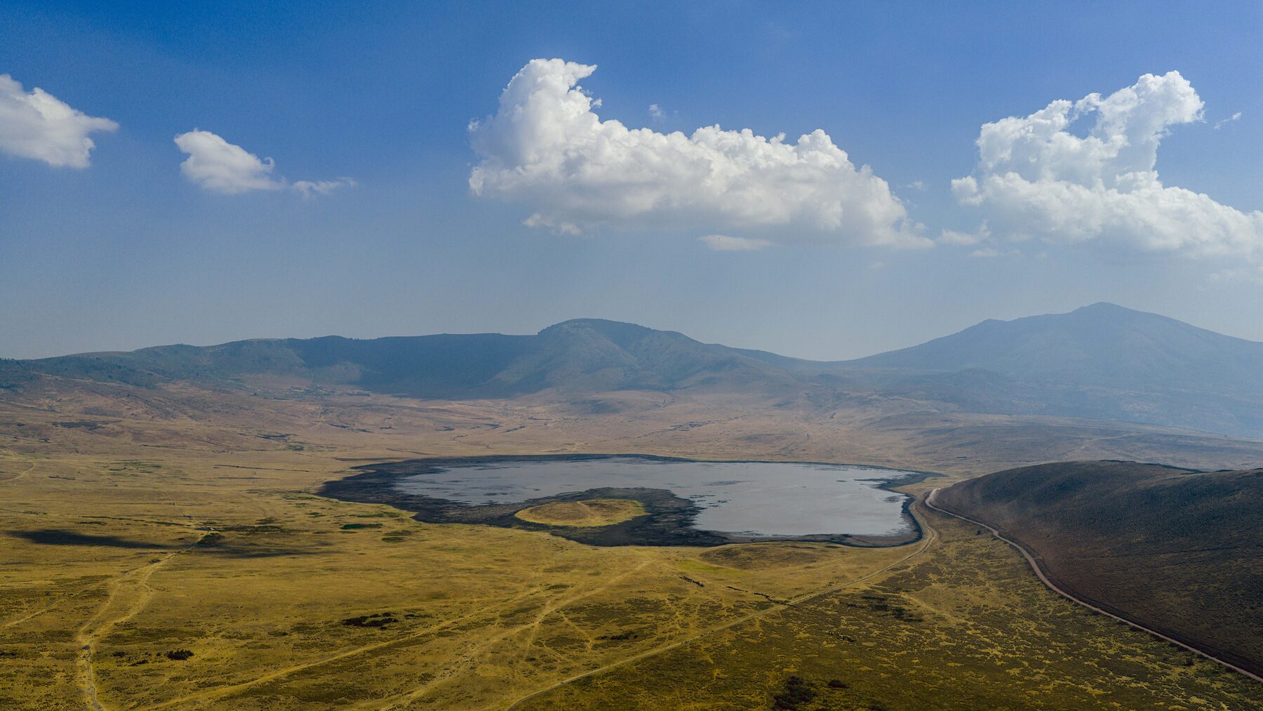 Aerial view of the vast Ngorongoro Crater floor and rim at golden hour