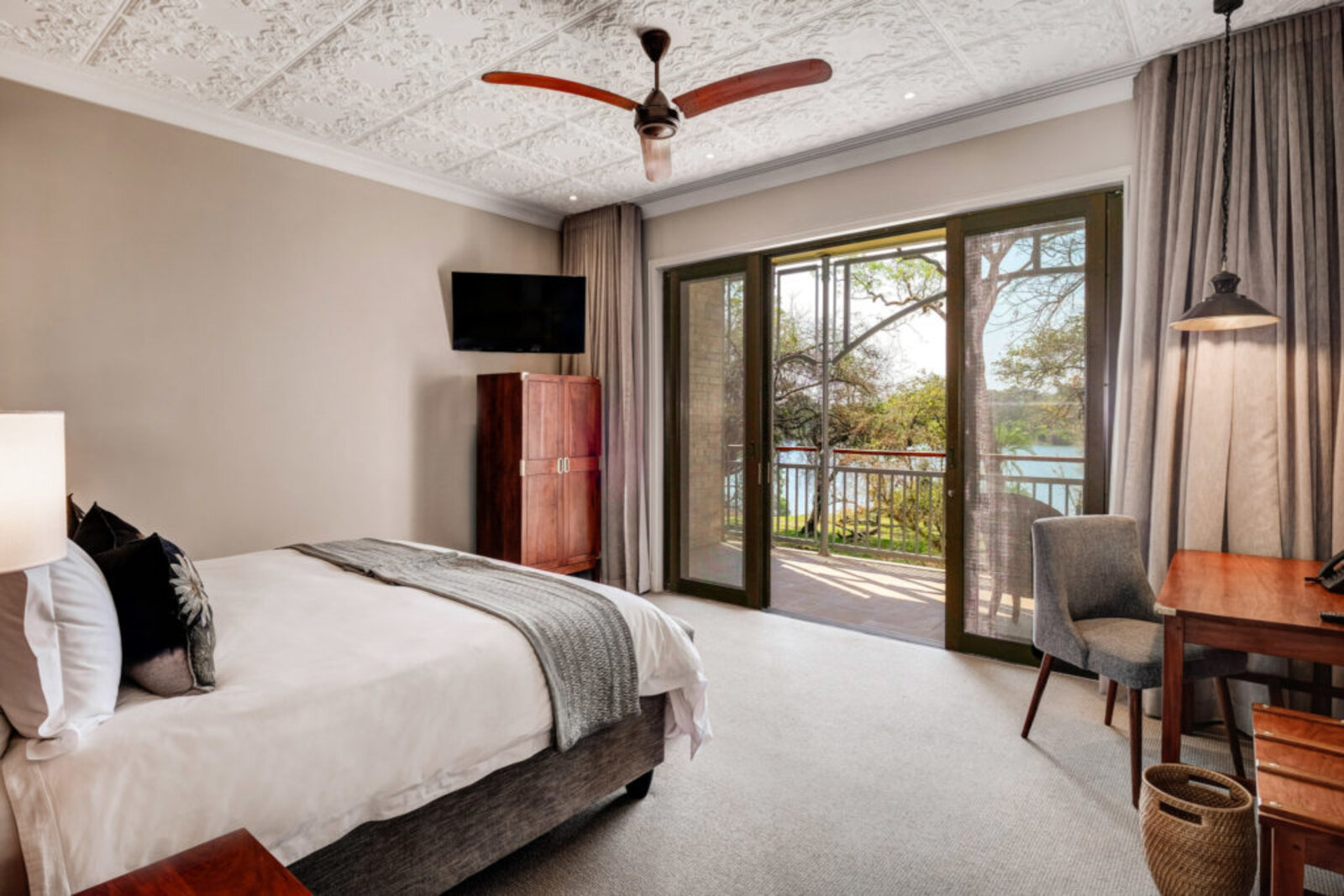 A river-facing deluxe room with a private balcony at The Palm River Hotel