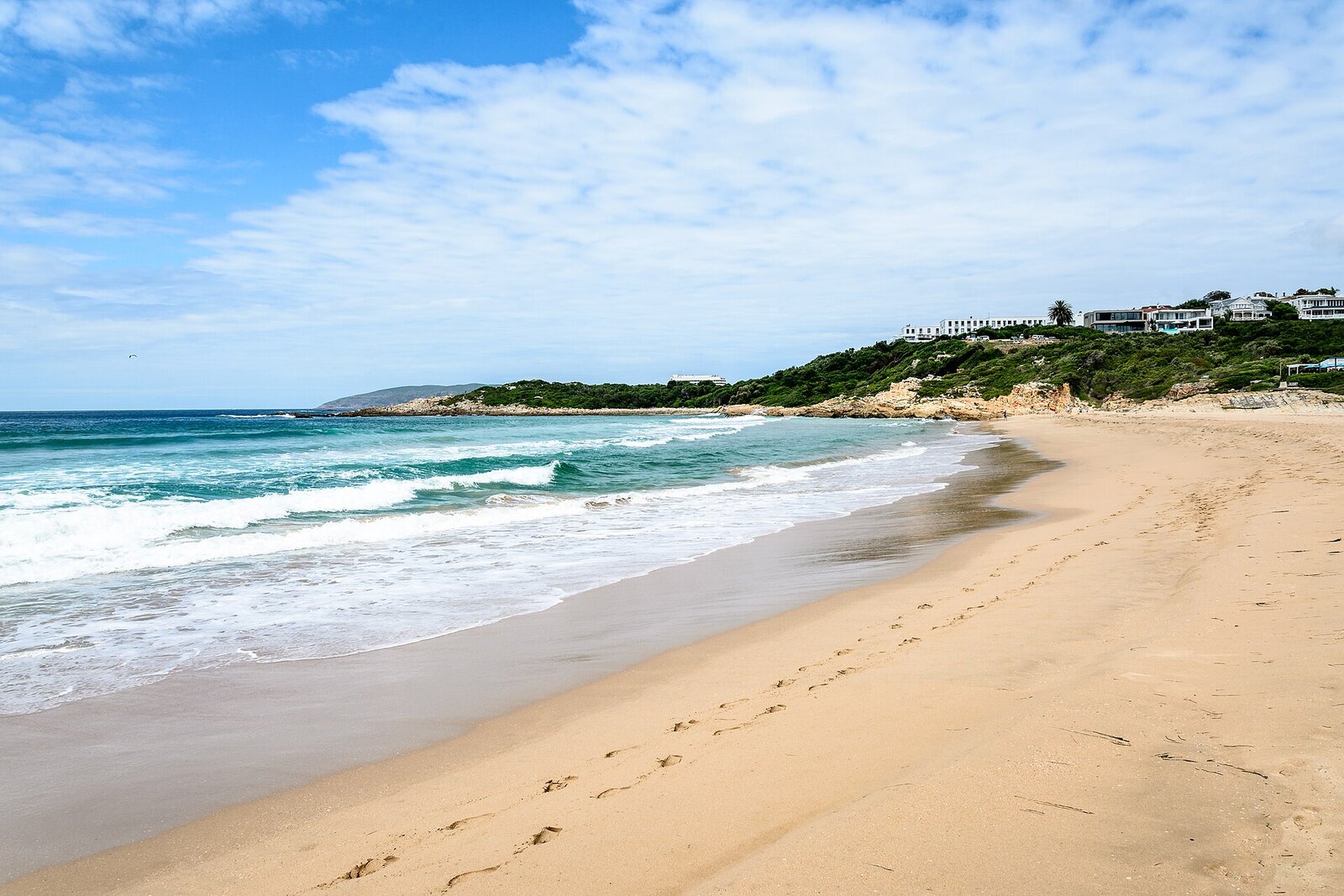 The wide golden sweep of Central Beach at Plettenberg Bay with the town behind