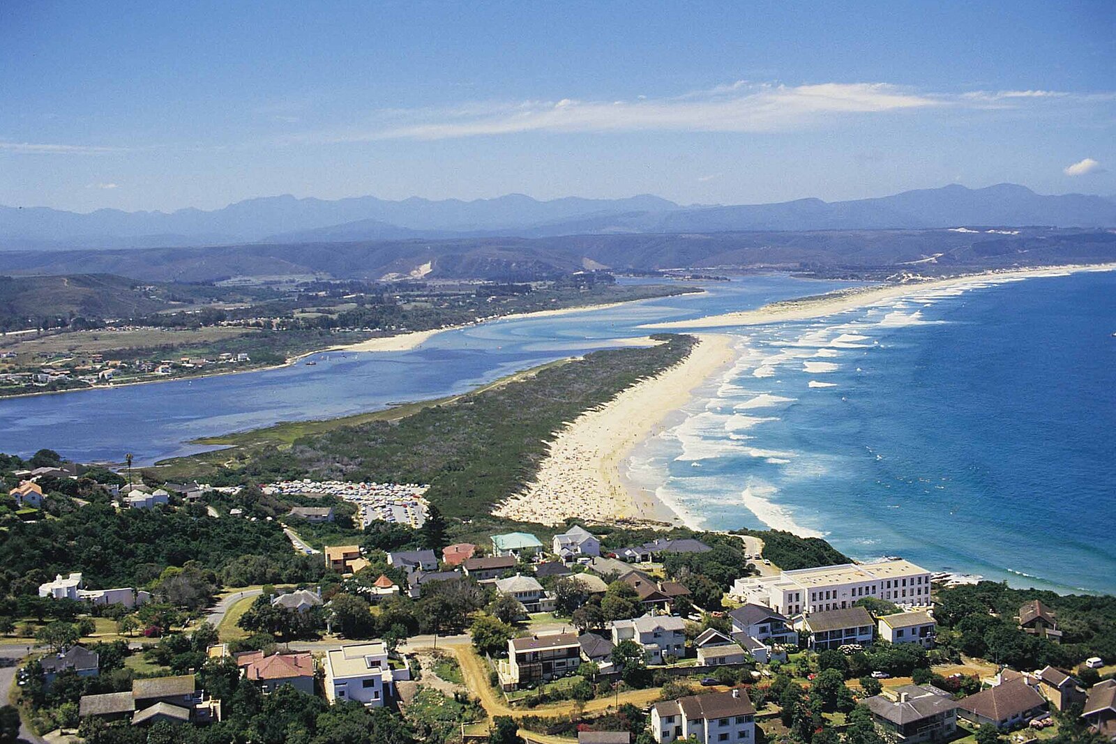 Aerial golden-hour view over the whole sweep of Plettenberg Bay and its beaches