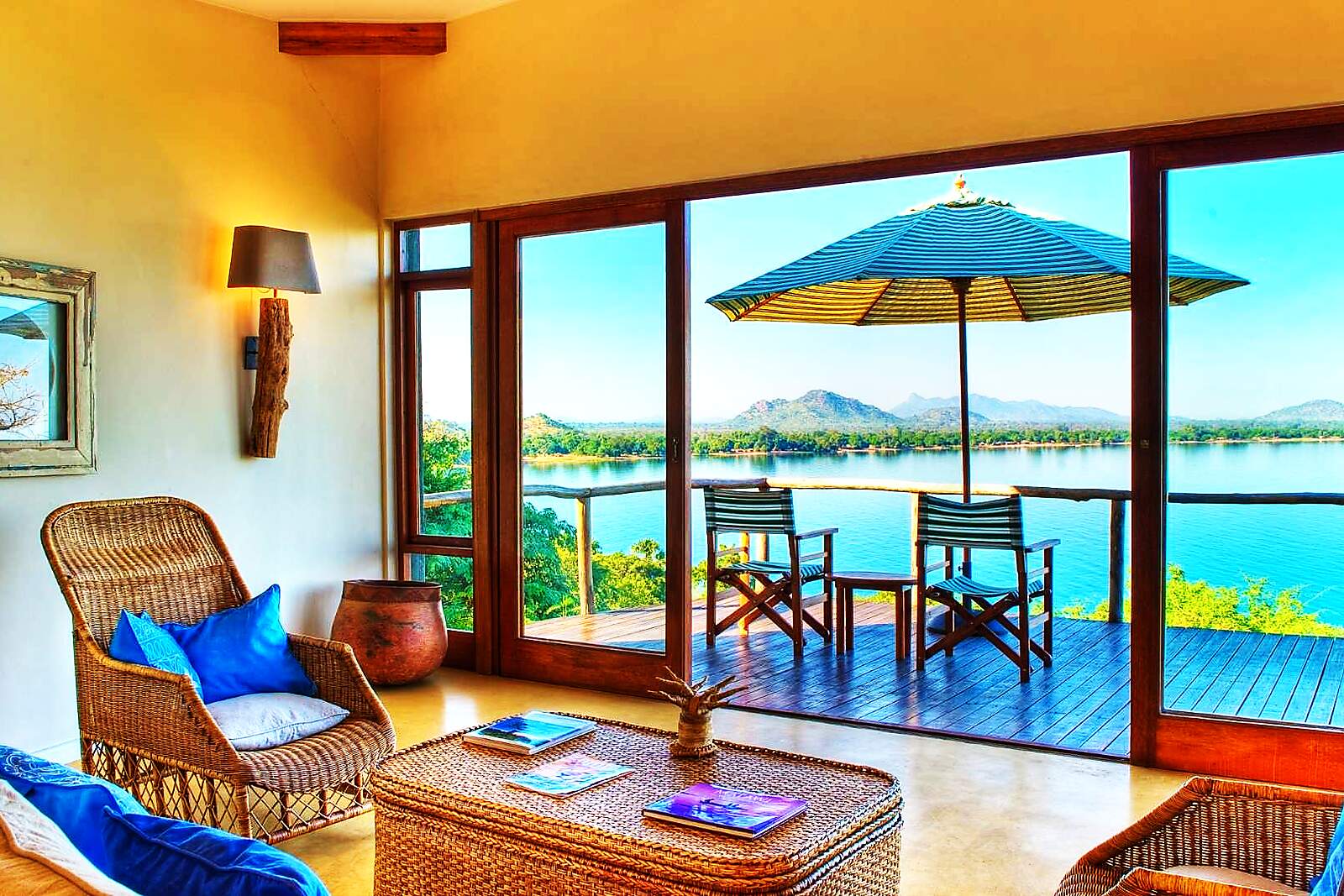 A lounge with an umbrella and daybeds overlooking Lake Malawi