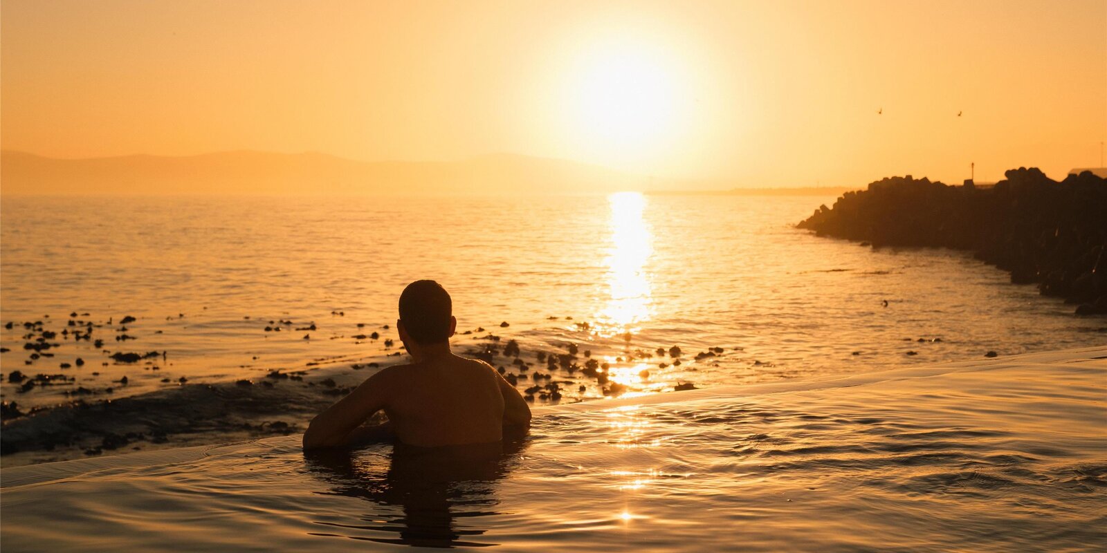 The rim-flow pool at the Radisson Collection Waterfront at sunset over the ocean