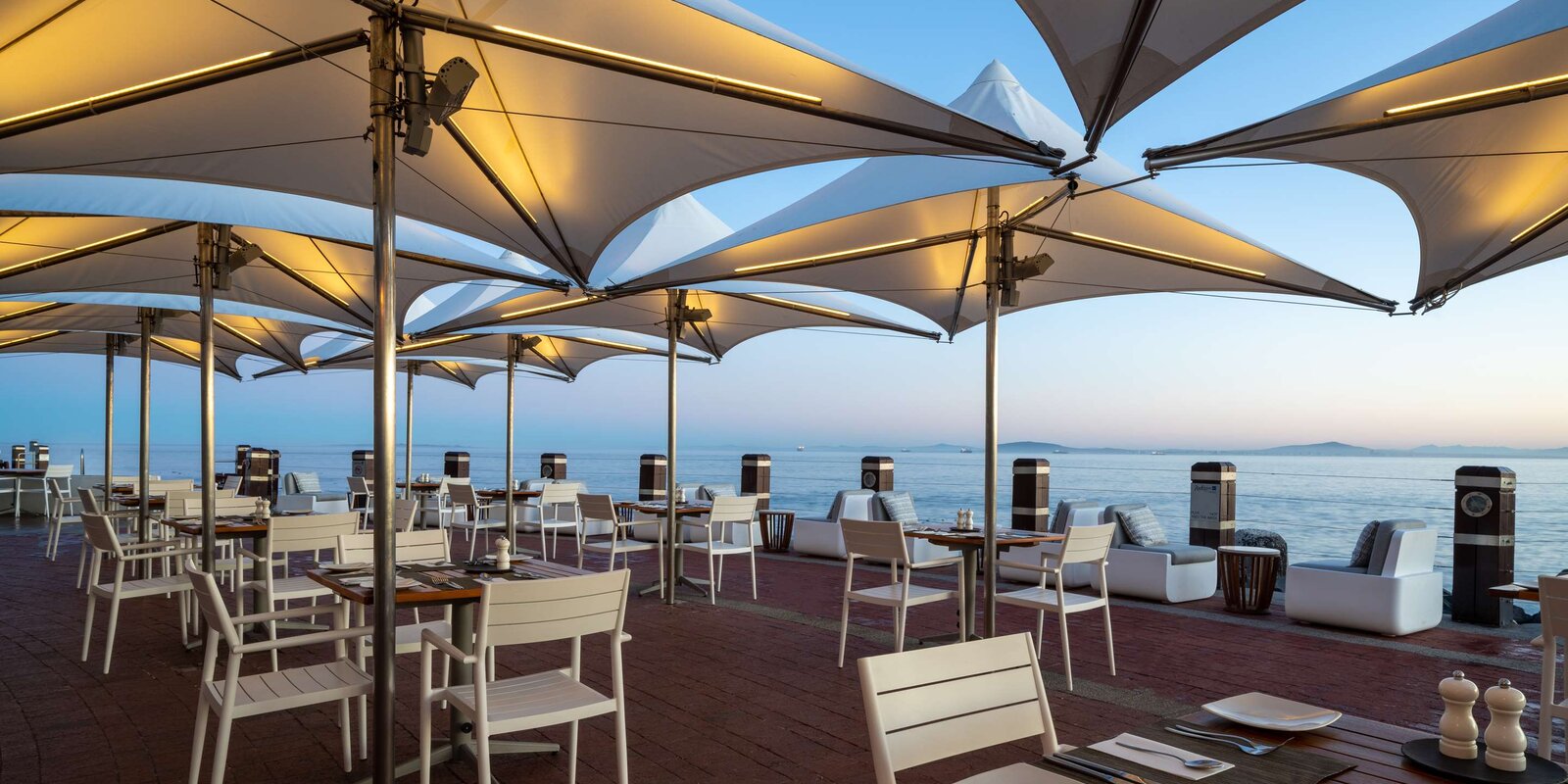 Tobago's terrace at the Radisson Collection Waterfront, umbrellas and tables over the Atlantic