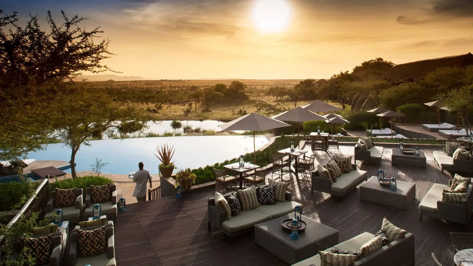 Luxury safari lodge with infinity pool overlooking a waterhole in the Serengeti