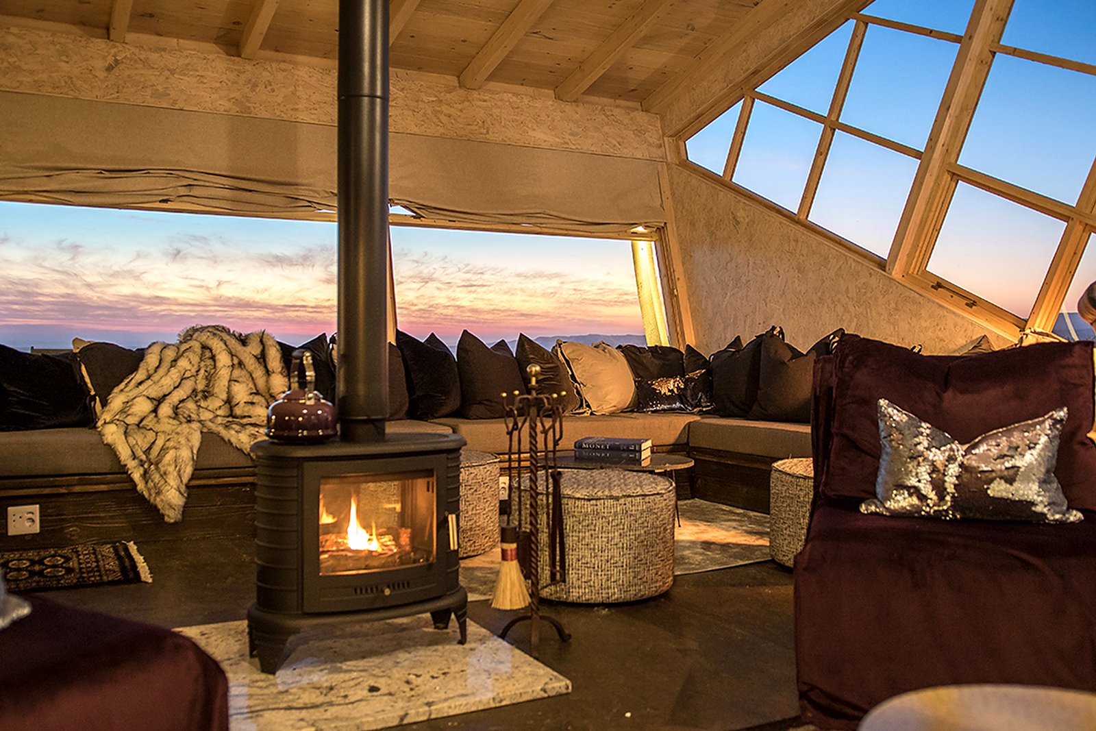 Wood-burning stove and cosy lounge interior at Shipwreck Lodge, Skeleton Coast