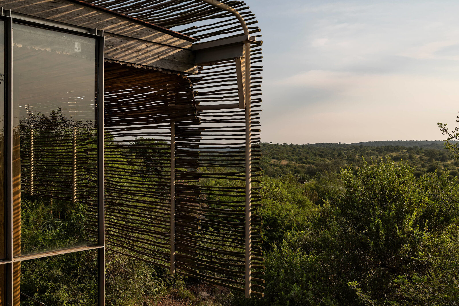 Singita Lebombo Long Bar lounge with sweeping timber ceiling and river outlook