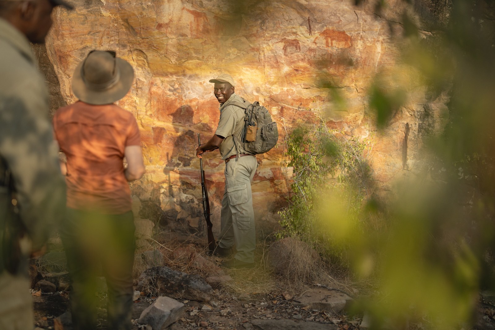 A guide and guest examining ancient San rock art in the Malilangwe Reserve