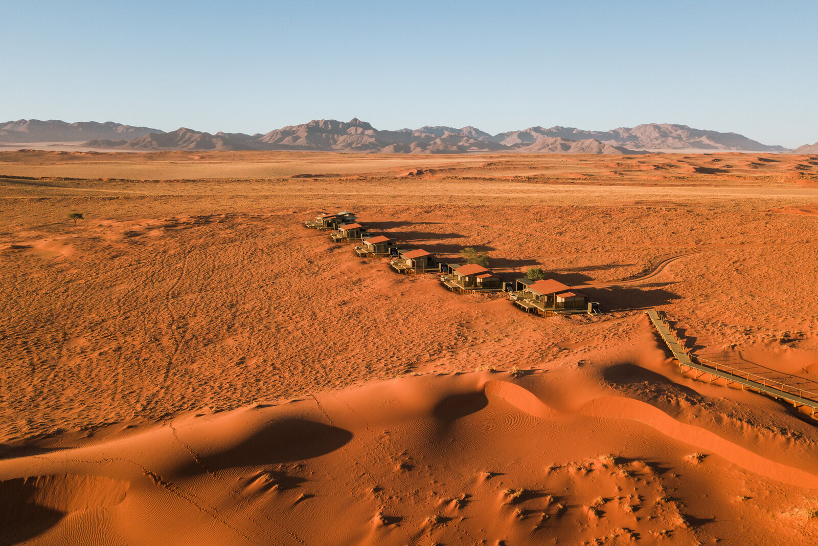 Open-fronted desert lodge chalet on a dune plateau in the NamibRand reserve