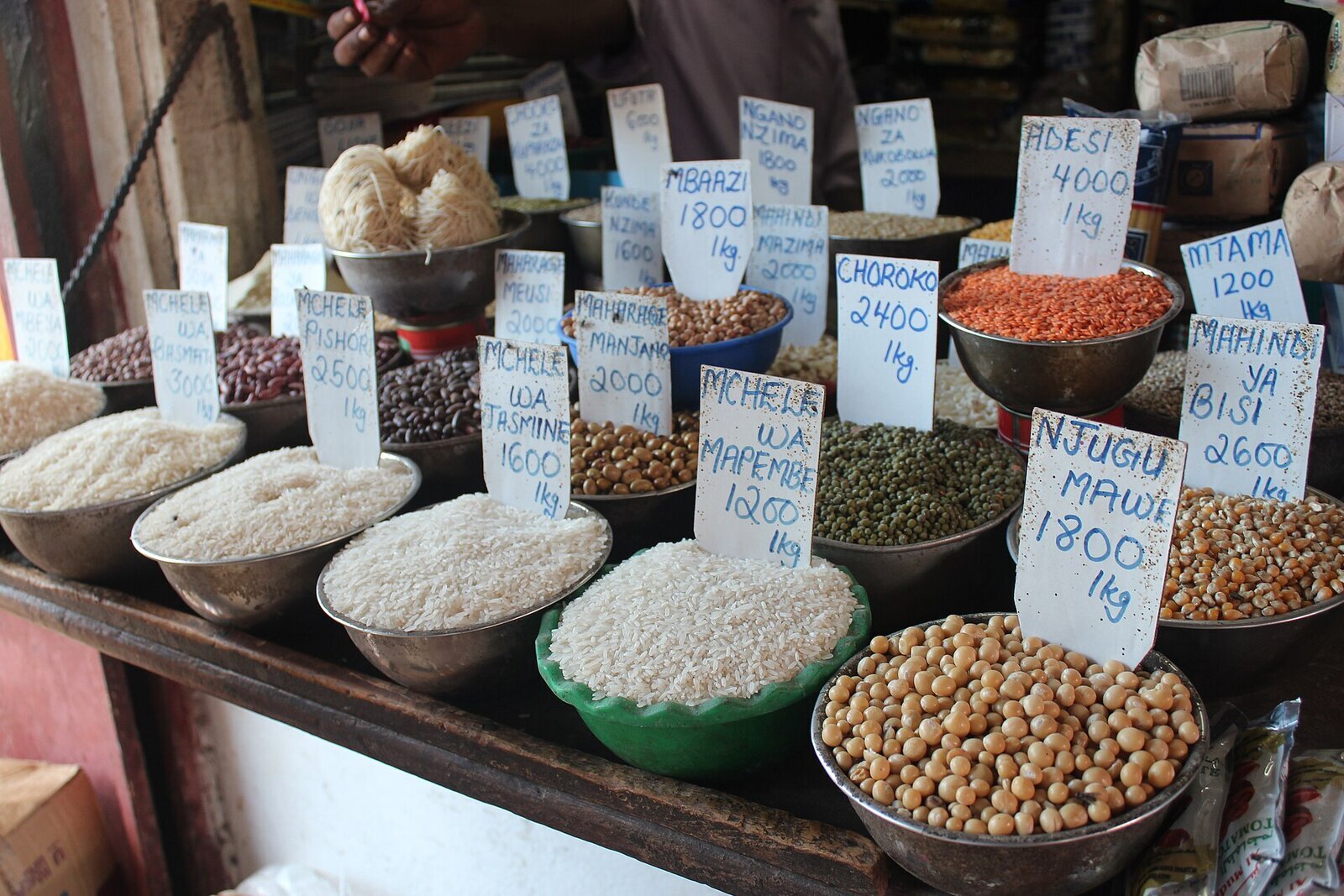Bowls of spices and grains with Swahili price signs at a Zanzibar market