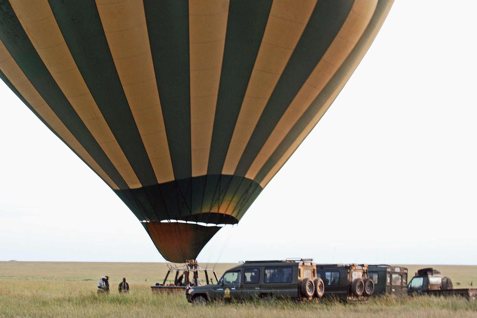 Hot-air balloon lifting off over the plains at dawn