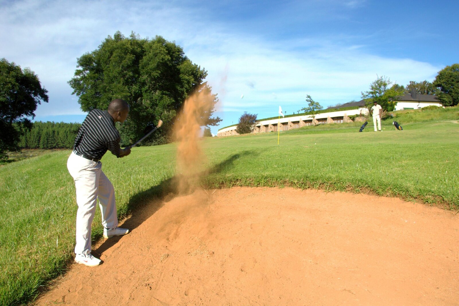 A golfer playing from a bunker at Elephant Hills golf course, Victoria Falls