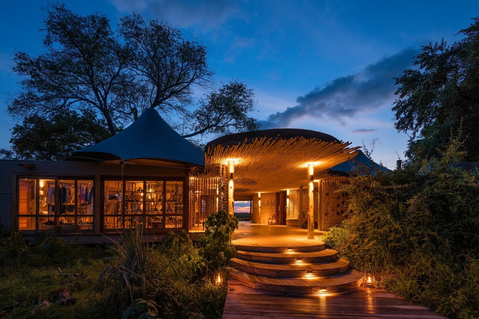A luxury camp lit up at dusk on the Okavango Delta floodplain on the full trifecta safari