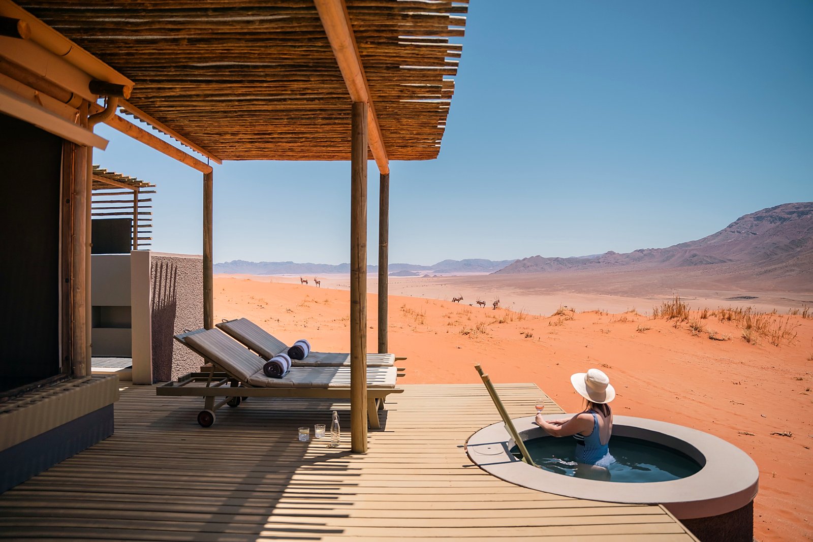 Private deck and plunge pool facing the golden NamibRand grasslands at Wolwedans