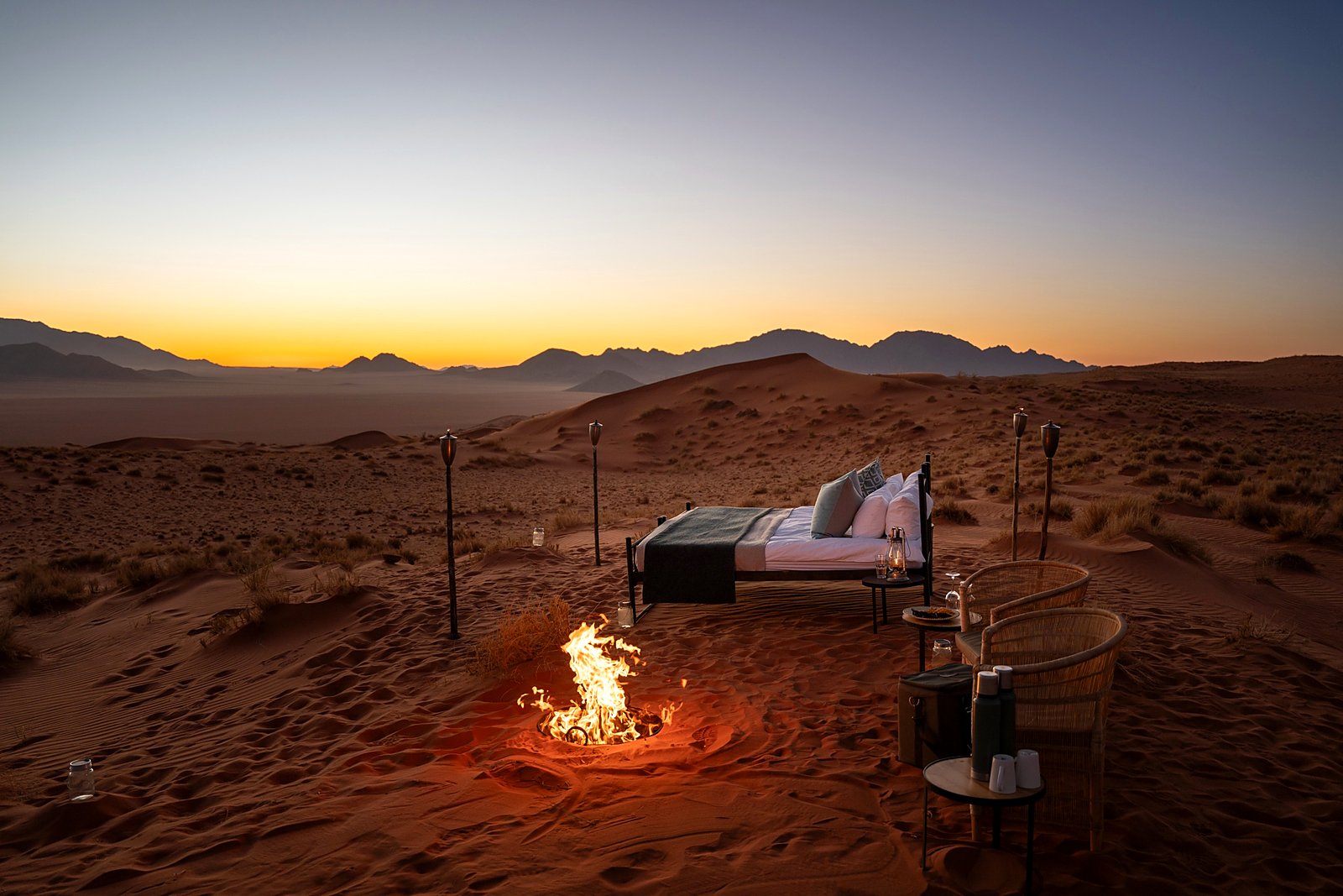 Wolwedans star bed and fire set out under the Milky Way in the NamibRand Reserve